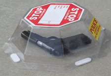 a plastic container with the word 'stop' on top of it, covering up a firearm