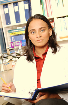 Image of Person in lab coat reviewing material.
