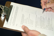 Image of a person filling out a document on a clipboard