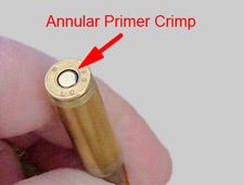 Hand holding a bullet, showing rear end and Annular Priming Crimp.