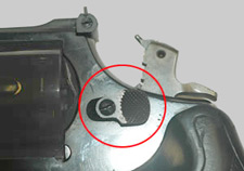 Close-up view of revolver handgun in cocked position with cylinder release device highlighted.