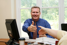Man at desk shaking hands