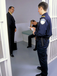 Imagen de un abogado reunido con un prisionero dentro de la celda de una prisin